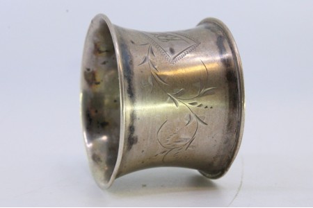 Argola de guardanapo em prata com motivos florais gravados envolvendo cartela para monograma.